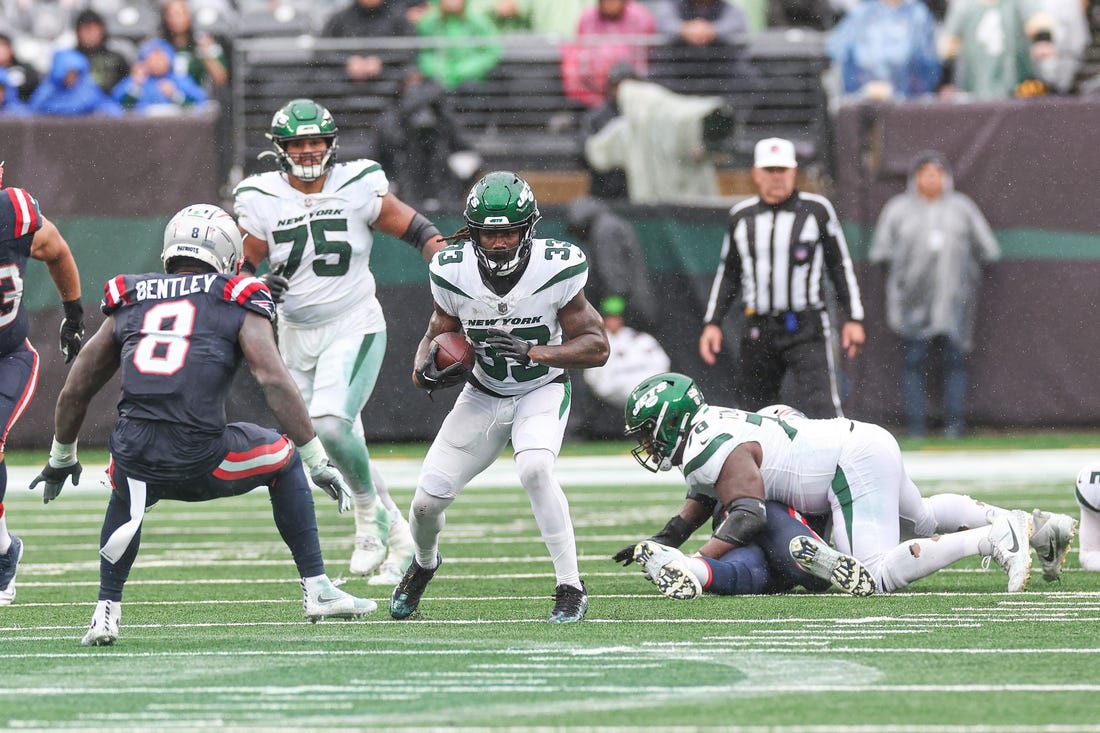 Sep 24, 2023; East Rutherford, New Jersey, USA; New York Jets running back Dalvin Cook (33) carries the ball asNew England Patriots linebacker Ja'Whaun Bentley (8) defends during the second half at MetLife Stadium. Mandatory Credit: Vincent Carchietta-USA TODAY Sports