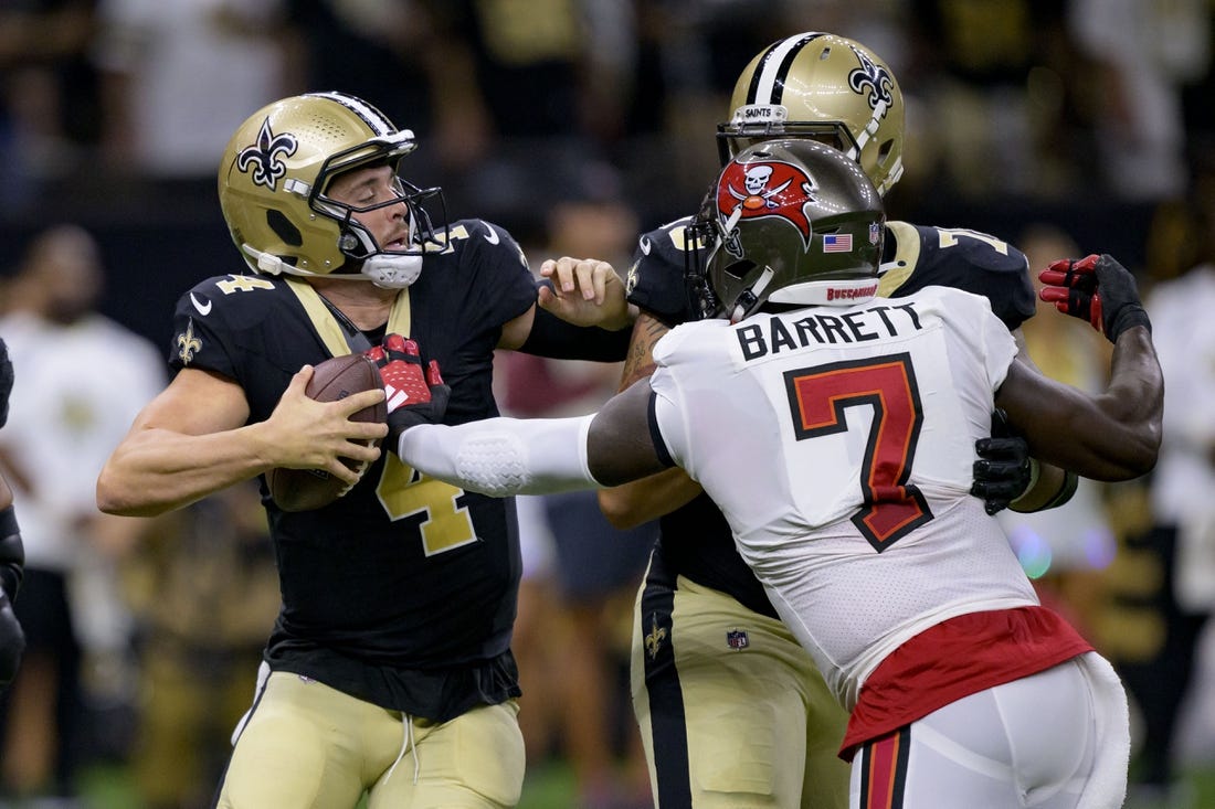 Oct 1, 2023; New Orleans, Louisiana, USA; New Orleans Saints quarterback Derek Carr (4) tries to escape the grasp of Tampa Bay Buccaneers linebacker Shaquil Barrett (7) during the first quarter at the Caesars Superdome. Mandatory Credit: Matthew Hinton-USA TODAY Sports