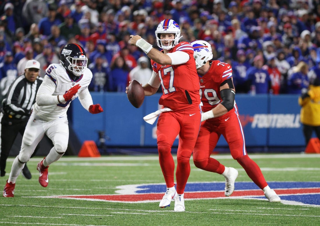 Buffalo Bills quarterback Josh Allen (17) directs his receivers as he is flushes out of the pocket by New York Giants linebacker Kayvon Thibodeaux (5).