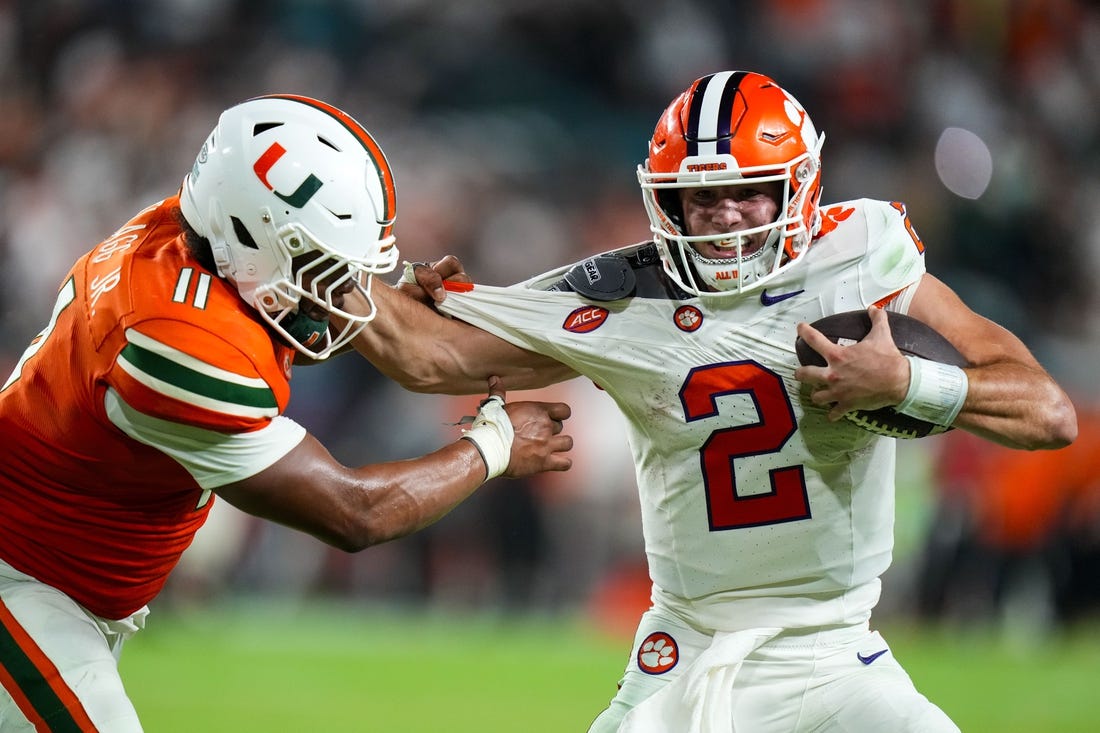 Oct 21, 2023; Miami Gardens, Florida, USA; Miami Hurricanes linebacker Corey Flagg Jr. (11) tackles Clemson Tigers quarterback Cade Klubnik (2) to win the game in over time at Hard Rock Stadium. Mandatory Credit: Rich Storry-USA TODAY Sports