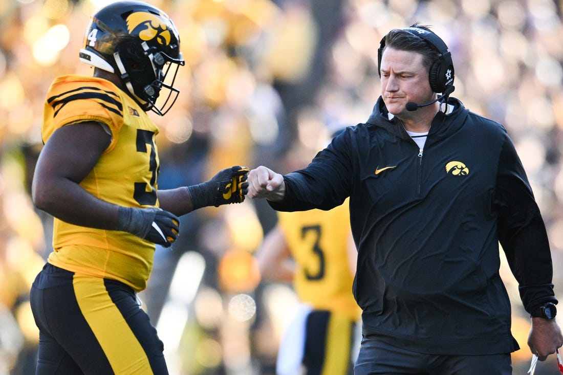 Iowa Hawkeyes assistant coach Brian Ferentz greets Big Ten leading tackler Jay Higgins (34) as he returns to the sideline during the second quarter against the Minnesota Golden Gophers at Kinnick Stadium. Mandatory Credit: Jeffrey Becker-USA TODAY Sports