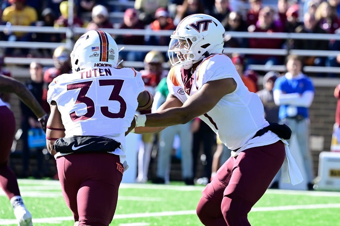 Nov 11, 2023; Chestnut Hill, Massachusetts, USA; Virginia Tech Hokies quarterback Kyron Drones (1) hands the ball to running back Bhayshul Tuten (33) during the first half against the Boston College Eagles at Alumni Stadium. Mandatory Credit: Eric Canha-USA TODAY Sports