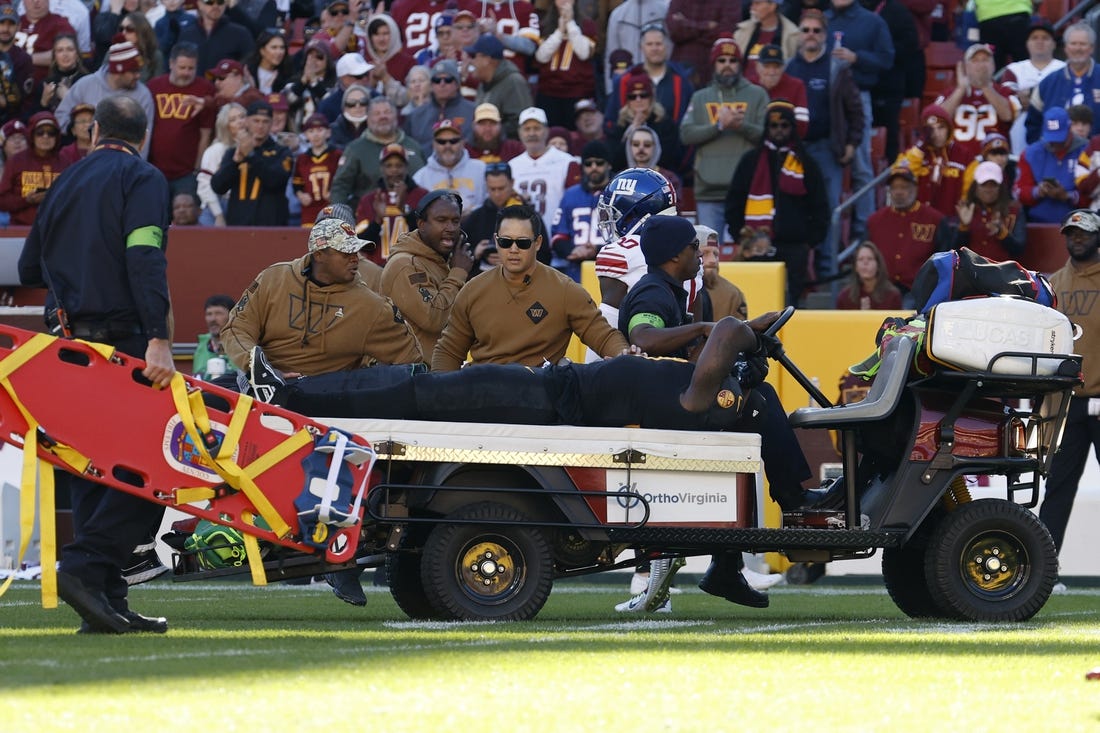 Nov 19, 2023; Landover, Maryland, USA; Washington Commanders defensive end Efe Obada (97) is carted off the field after being injured against the New York Giants during the first quarter at FedExField. Mandatory Credit: Geoff Burke-USA TODAY Sports