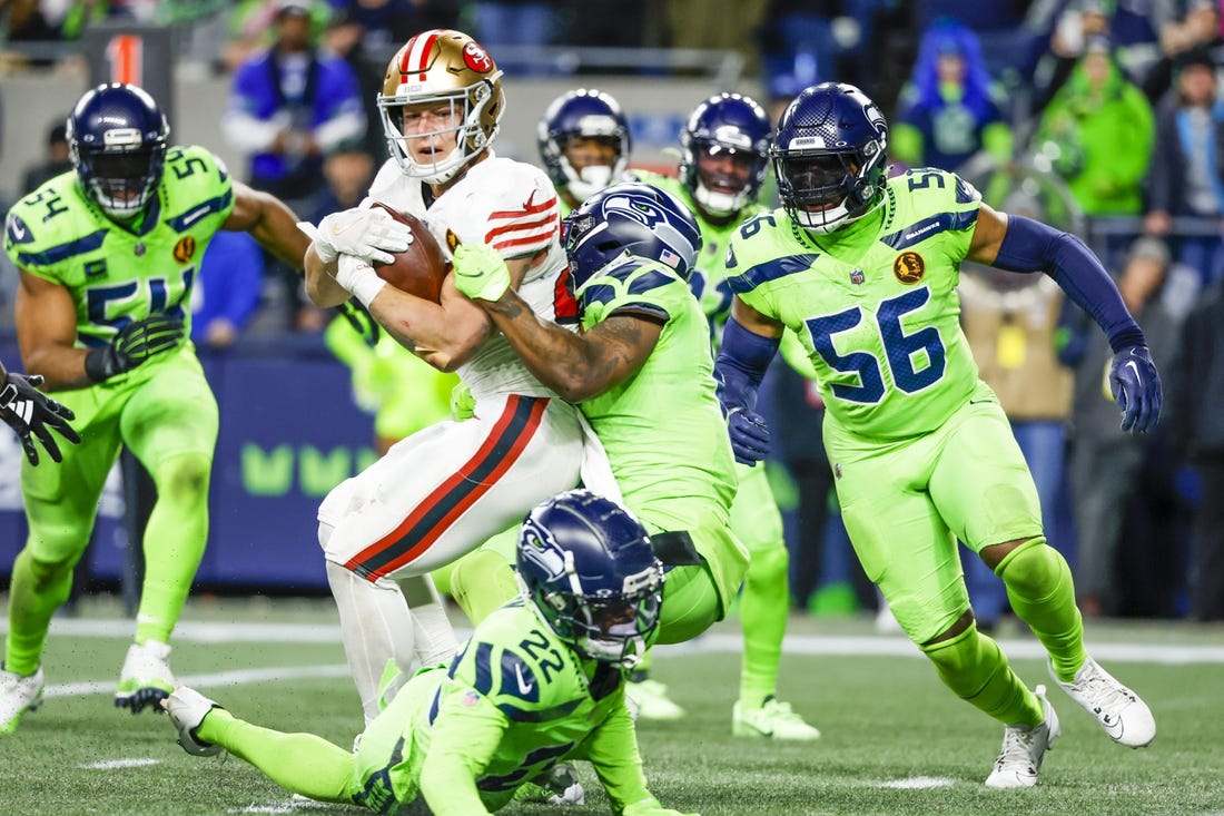Nov 23, 2023; Seattle, Washington, USA; San Francisco 49ers running back Christian McCaffrey (23) rushes for a touchdown against Seattle Seahawks safety Quandre Diggs (6) and linebacker Jordyn Brooks (56) during the second quarter at Lumen Field. Mandatory Credit: Joe Nicholson-USA TODAY Sports