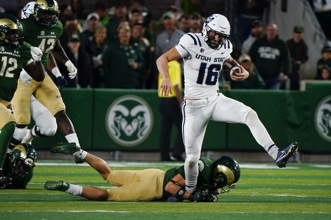 Oct 15, 2022; Fort Collins, Colorado, USA; Utah State Aggies quarterback Levi Williams (16) can't escape the grasp of a Colorado State Rams defender at Sonny Lubick Field at Canvas Stadium. Mandatory Credit: Michael Madrid-USA TODAY Sports