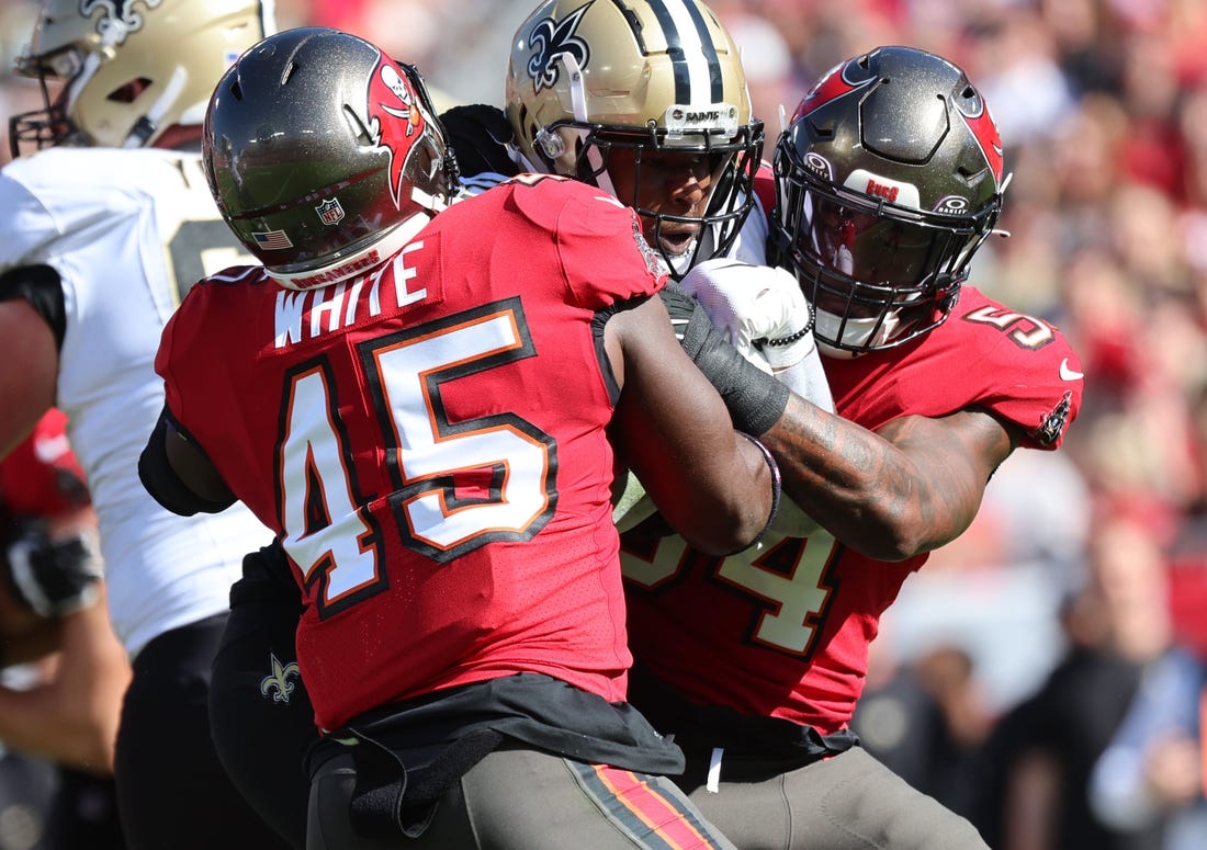 Dec 31, 2023; Tampa, Florida, USA; New Orleans Saints running back Jamaal Williams (21) runs with the ball as Tampa Bay Buccaneers linebacker Devin White (45) and linebacker Lavonte David (54) tackle during the first quarter at Raymond James Stadium. Mandatory Credit: Kim Klement Neitzel-USA TODAY Sports
