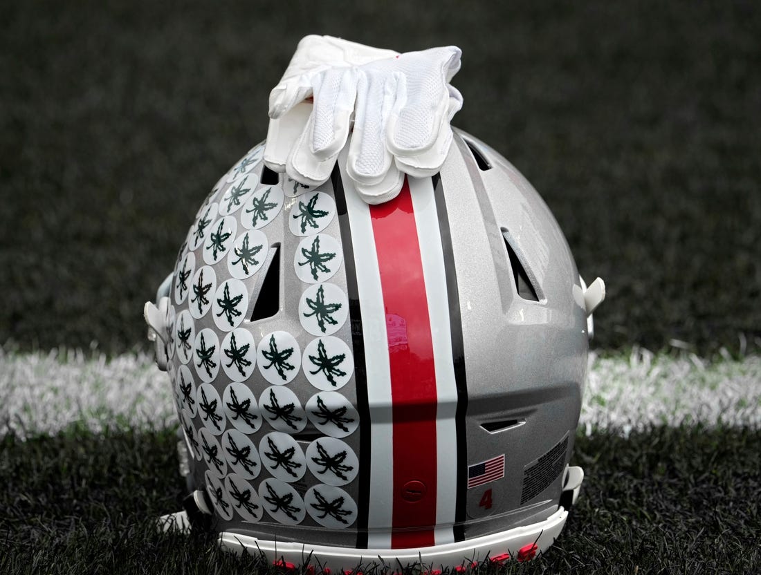 Oct. 14, 2023; Lafayette, In., USA; 
Gloves lie on top of the helmet of Ohio State Buckeyes wide receiver Julian Fleming (4) before Saturday's NCAA Division I football game against the Purdue Boilermakers at Ross-Ade Stadium in Lafayette.