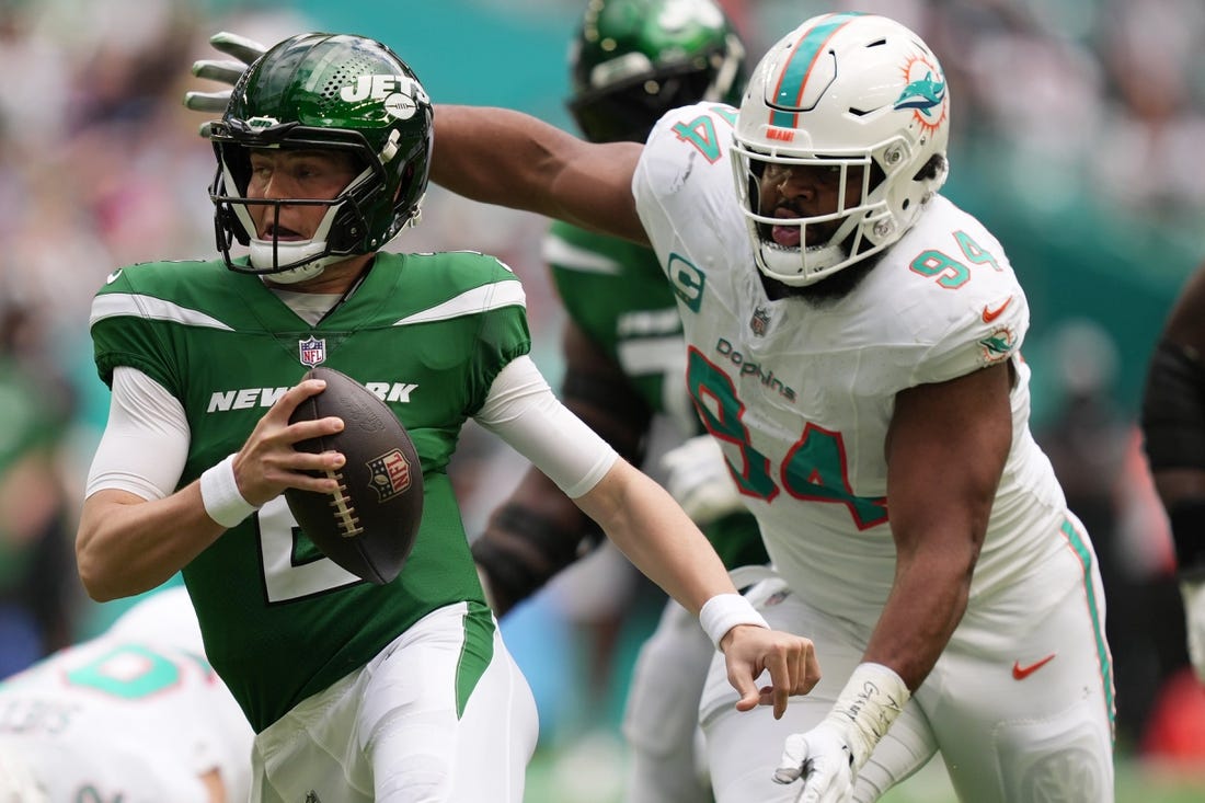 New York Jets quarterback Zach Wilson (2) tries to elude the pressure of Miami Dolphins defensive tackle Christian Wilkins (94) during the first half of an NFL game at Hard Rock Stadium in Miami Gardens, Dec. 17, 2023.