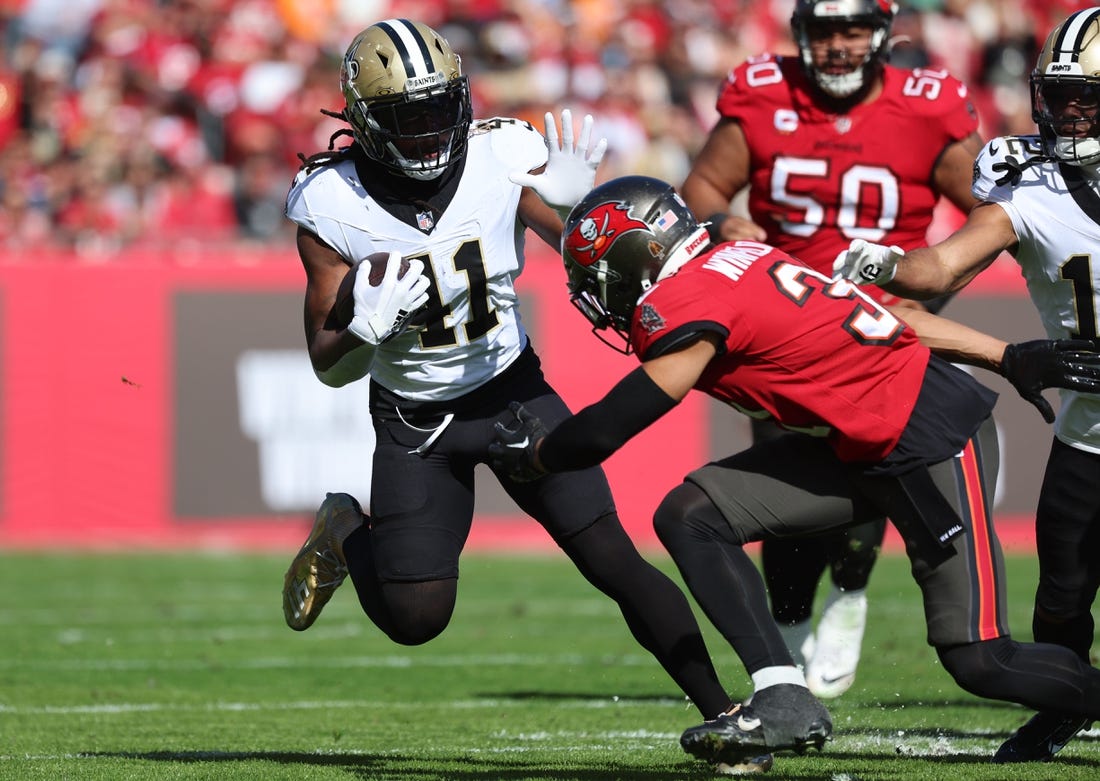 Dec 31, 2023; Tampa, Florida, USA;New Orleans Saints running back Alvin Kamara (41)  stiff arms Tampa Bay Buccaneers safety Antoine Winfield Jr. (31) during the first quarter at Raymond James Stadium. Mandatory Credit: Kim Klement Neitzel-USA TODAY Sports