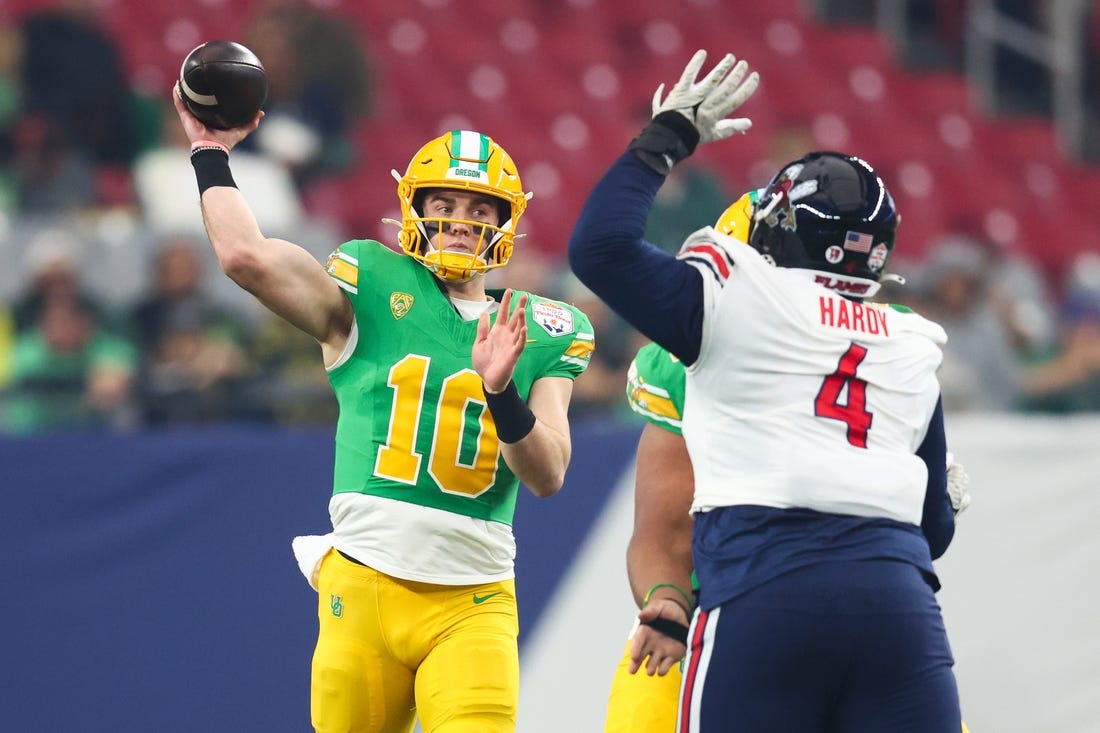 Jan 1, 2024; Glendale, AZ, USA; Oregon Ducks quarterback Bo Nix (10) throws the ball under pressure from Liberty Flames defensive tackle Jay Hardy (4) during the first quarter of the 2024 Fiesta Bowl at State Farm Stadium. Mandatory Credit: Mark J. Rebilas-USA TODAY Sports