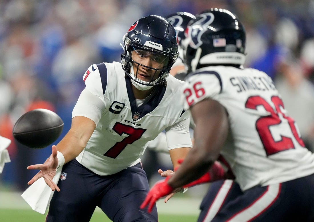 Houston Texans quarterback C.J. Stroud (7) tosses the ball to Houston Texans running back Devin Singletary (26) on Saturday, Jan. 6, 2024, during a game against the Houston Texans at Lucas Oil Stadium in Indianapolis.