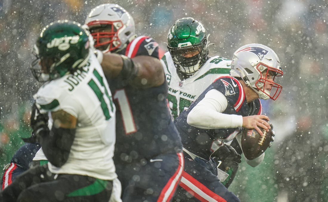 Jan 7, 2024; Foxborough, Massachusetts, USA; New England Patriots quarterback Bailey Zappe (4) under pressure from the New York Jets in the second quarter at Gillette Stadium. Mandatory Credit: David Butler II-USA TODAY Sports