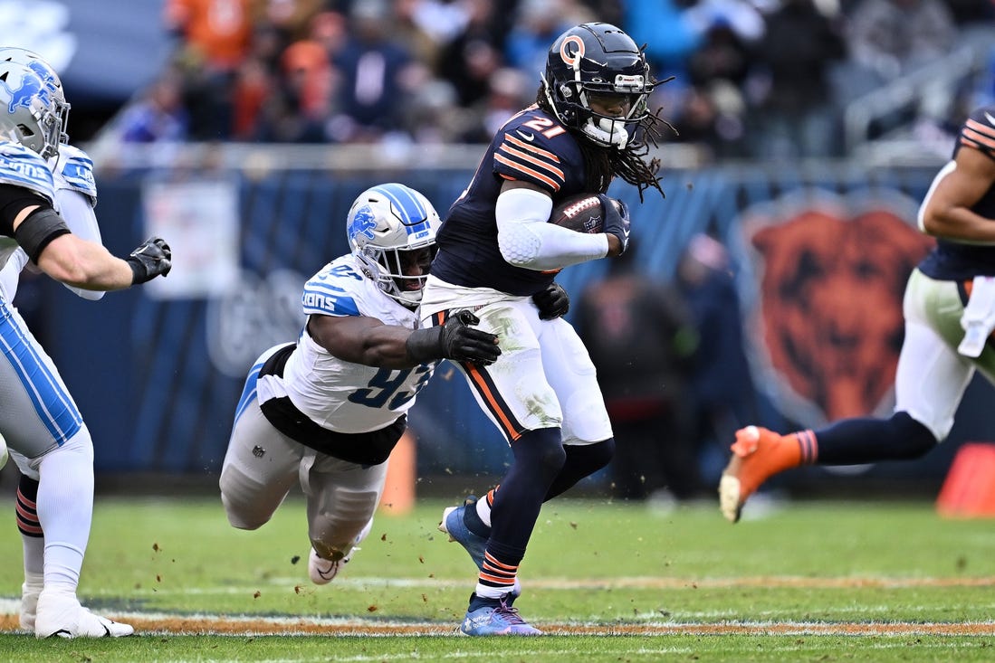 Dec 10, 2023; Chicago, Illinois, USA;  Detroit Lions defensive lineman Josh Paschal (93) hangs on to Chicago Bears running back D'Onta Foreman (21) to make the tackle in the second half at Soldier Field. Mandatory Credit: Jamie Sabau-USA TODAY Sports