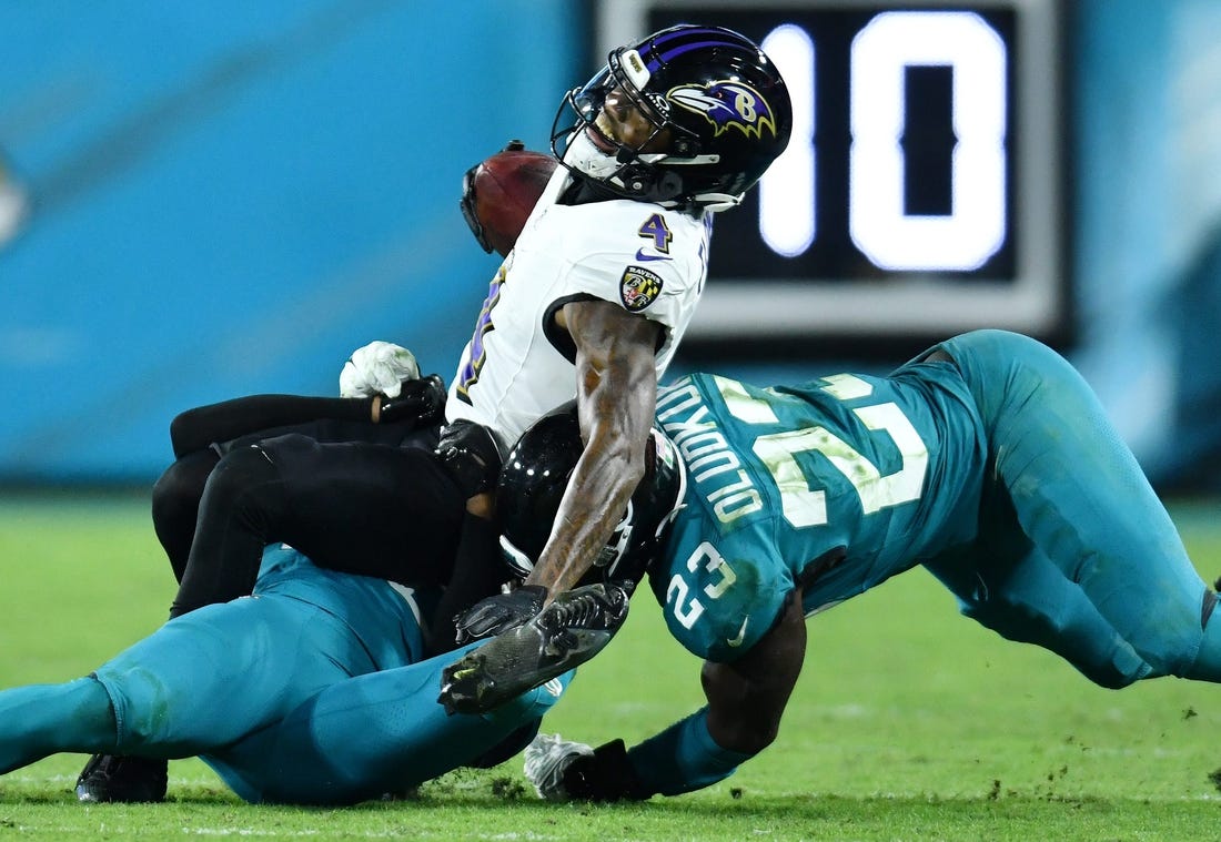 Jacksonville Jaguars cornerback Montaric Brown (30) and linebacker Foyesade Oluokun (23) make the tackle on Baltimore Ravens wide receiver Zay Flowers (4) during third quarter action. The Jacksonville Jaguars hosted the Baltimore Ravens at EverBank Stadium in Jacksonville, Florida Sunday Night, December 17, 2023. The Jaguars trailed 10 to 0 at the half and lost 23 to 7. [Bob Self/Florida Times-Union]